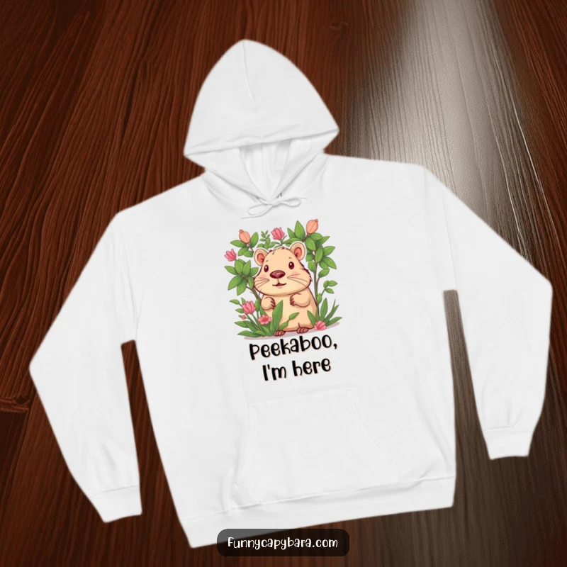 Funny hoodie showcasing a capybara curiously peeking from behind abundant green foliage, full of intrigue.